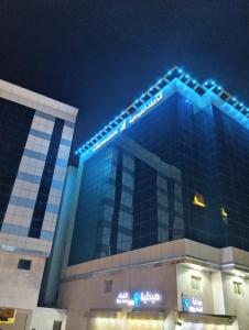 a building with blue lights on top of it at فندق الخلفاء الفيصلية الفندقية in Makkah +22 photos