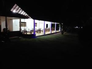 een gebouw met tafels en stoelen in het donker bij JunglevistaLake in Dambulla +5 foto's