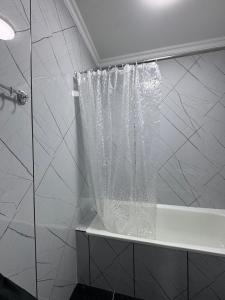 a shower curtain in a bathroom with a tub at тёплое гнёздышко in Astana +8 photos
