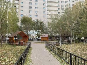 a park with a fence and a building at тёплое гнёздышко in Astana