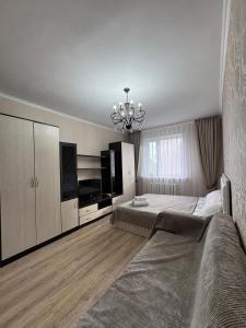 a bedroom with a large bed and a chandelier at тёплое гнёздышко in Astana