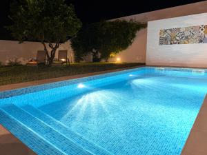 ein nachts beleuchtetes Schwimmbad in der Unterkunft Casa das Laranjeiras in Torrão