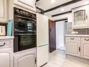 eine Küche mit weißen Schränken und einem Backofen in der Unterkunft Sunnyside Cottage Retreat in Penwithick