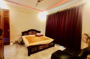 a bedroom with a bed and a red curtain at SR Farm Stay in Turkapally