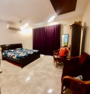 a bedroom with a bed and a couch and a chair at SR Farm Stay in Turkapally