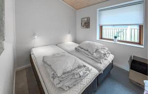Un dormitorio con dos camas deshechas y una ventana. en Lovely Home In Sunds With House Sea View, en Sunds