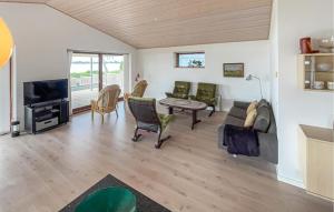 a living room with a couch and a tv at Lovely Home In Sunds With House Sea View in Sunds
