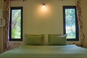 a bedroom with a bed with two windows at Baan Reena Lanta Resort in Ko Klang +40 photos