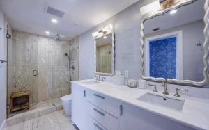 a white bathroom with a sink and a shower at Luxury Three Bedroom Oceanfront Penthouse with Ter in Palm Beach