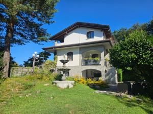 a large white house on a hill with trees at Al Picchio Verde A.P.S. in Cunardo