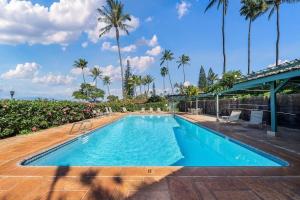 Una gran piscina con palmeras al fondo. en International Colony Club 43 · ICC 43 Spacious 2BD Cottage Walk, en Lahaina
