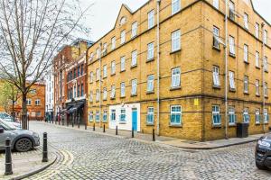 a large brick building on a cobblestone street at Alexander Fleming House, London in London