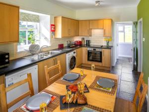 a kitchen with a wooden table with a dining room at Clayhills Cottage - Uk5833 in Rattray