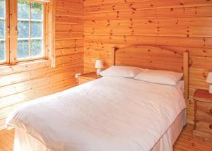 a bedroom with a white bed in a wooden room at Home Farm in Stillingfleet