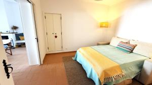 ein Schlafzimmer mit einem Bett und einen Flur mit einer Tür in der Unterkunft Casa das Laranjeiras in Torrão + 40 Fotos