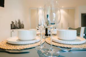 a table with two wine glasses and plates on it at Studio House by Brookland Stays Serviced Accommodation Short Lets Feltham with Free WiFi in New Bedfont