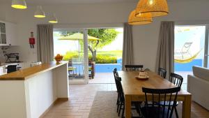 eine Küche und ein Esszimmer mit Tisch und Stühlen in der Unterkunft Casa das Laranjeiras in Torrão