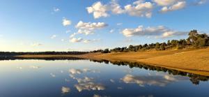 ein Fluss mit einer Spiegelung von Wolken im Wasser in der Unterkunft Casa das Laranjeiras in Torrão