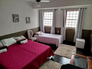 a bedroom with two beds and two windows at Sollar da Chica Vesperata in Diamantina +24 photos