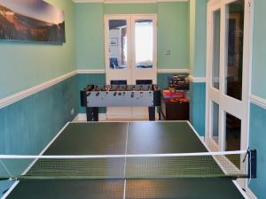 a room with a ping pong table in it at Ron's House in Broadstairs