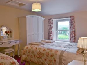 a bedroom with a bed and a window at Bellegrove Cottage in Watermillock