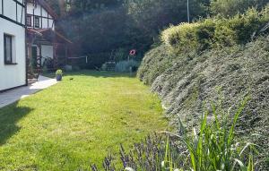 ein grasbewachsener Hof neben einem Haus mit einer Mauer in der Unterkunft 2 Bedroom Gorgeous Home In Debina in Dębina + 8 Fotos