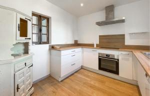 LavilledieuにあるCozy Home In Lavilledieuの白いキャビネットとコンロ付きオーブンを備えたキッチン