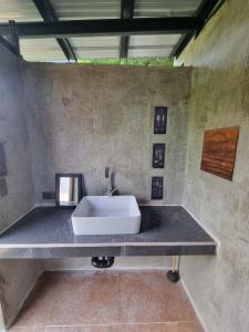 un bagno con un lavandino su un muro di cemento di Miracle's Farm at Tarlac 