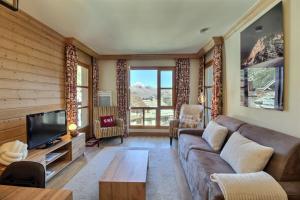 アーク 1950にあるArc 1950, Appartement 2 chambres 6 pers, Vue MontBlanc, Sauna, Hammam, Jacuzzi, Piscine intérieure et extérieureのソファとテレビのあるリビングルーム