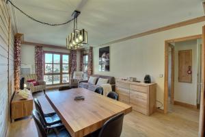 アーク 1950にあるArc 1950, Appartement 2 chambres 6 pers, Vue MontBlanc, Sauna, Hammam, Jacuzzi, Piscine intérieure et extérieureの木製のテーブルと椅子のあるリビングルーム