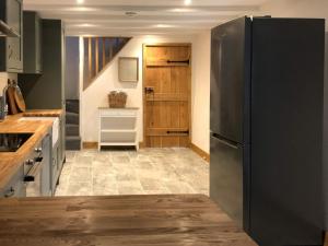 a kitchen with a black refrigerator and a staircase at Middle Hanter - Uk37355 in Old Radnor