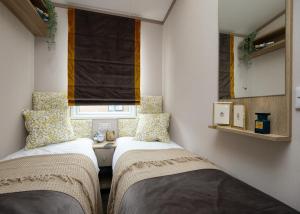 チャペル・セント・レオナルズにあるGolden Anchor Caravan Parkの窓のある小さな部屋にベッドが2つある