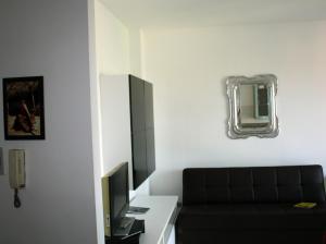 ガルバニャーテ・ミラネーゼにあるEasy Arese Apartmentのリビングルーム(黒いソファ、鏡付)