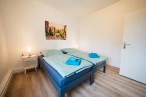ein Schlafzimmer mit einem blauen Bett und einem Gemälde an der Wand in der Unterkunft Zentrale Wohlfühlwohnung - Ideal für Ihren Urlaub oder die Geschäftsreise in Magdeburg