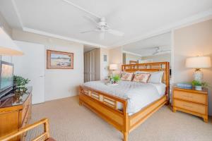 a bedroom with a wooden bed and a television at Whaler 712 · WHA 712 Kaanapali OceanFront Condo w Ocean Views in Lahaina +61 photos