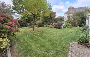 a garden with a tree in the middle of a yard at 5 Bedroom Lovely Home In Saint-Martin-Des-Champ in Saint-Martin-des-Champs +22 photos