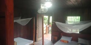a bedroom with a bed with a mosquito net at Avocados homestay in Banlung
