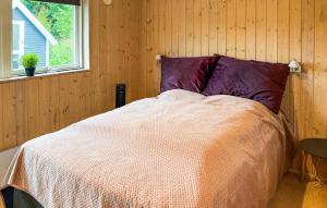 a bedroom with a bed in a wooden wall at 3 Bedroom Stunning Home In Hovborg in Hovborg