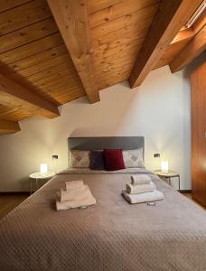 a bedroom with a large bed with towels on it at Dimore Al Borgo in Montagnana