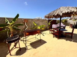 a patio with a table and chairs and an umbrella at Vilas na areia aparthotel in Sal Rei