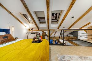 ウッチにあるLumina luxury apartments on Piotrkowska Streetのロフトにある大きな黄色いベッドのある寝室 +18枚の写真