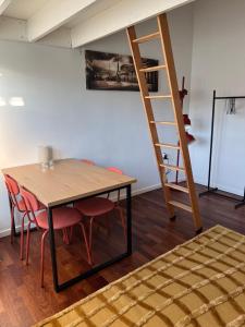 comedor con mesa, sillas y escalera en Convenient apartment - close to everything, en Odense