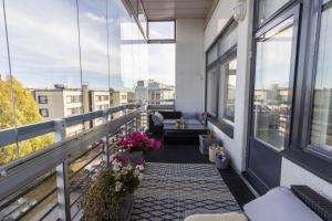 a balcony with a couch and flowers on a building at Big river view city apartment in Rovaniemi