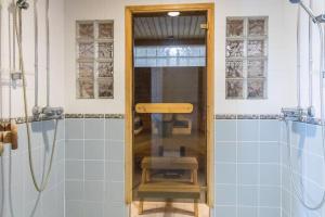 a bathroom with a shower and a glass door at Big river view city apartment in Rovaniemi