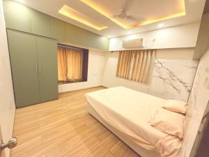 a small room with a bed and a cabinet at Villa Atharva in Alibaug