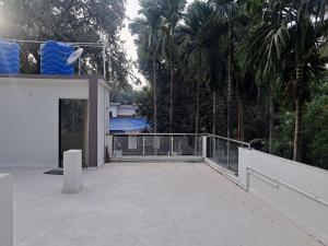 a balcony of a house with palm trees at Villa Atharva in Alibaug