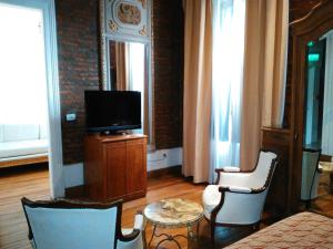a living room with a tv and a table and chairs at Hotel A&B Internacional in Buenos Aires +87 photos