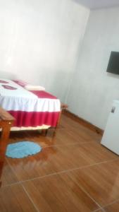 a room with a bed and a wooden floor at Hostel Lençóis em Santo Amaro MA in Santo Amaro