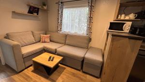 una sala de estar con un sofá y una mesa en Mobil home de 44m2, en La Palmyre
