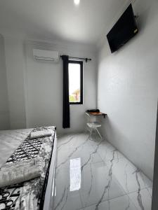 a bedroom with a bed and a television on the wall at Dentalinn in Lamglumpang